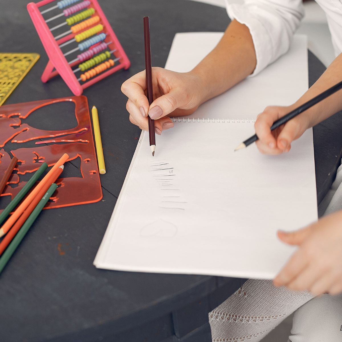 handwriting tutor showing student how to hold a pencil