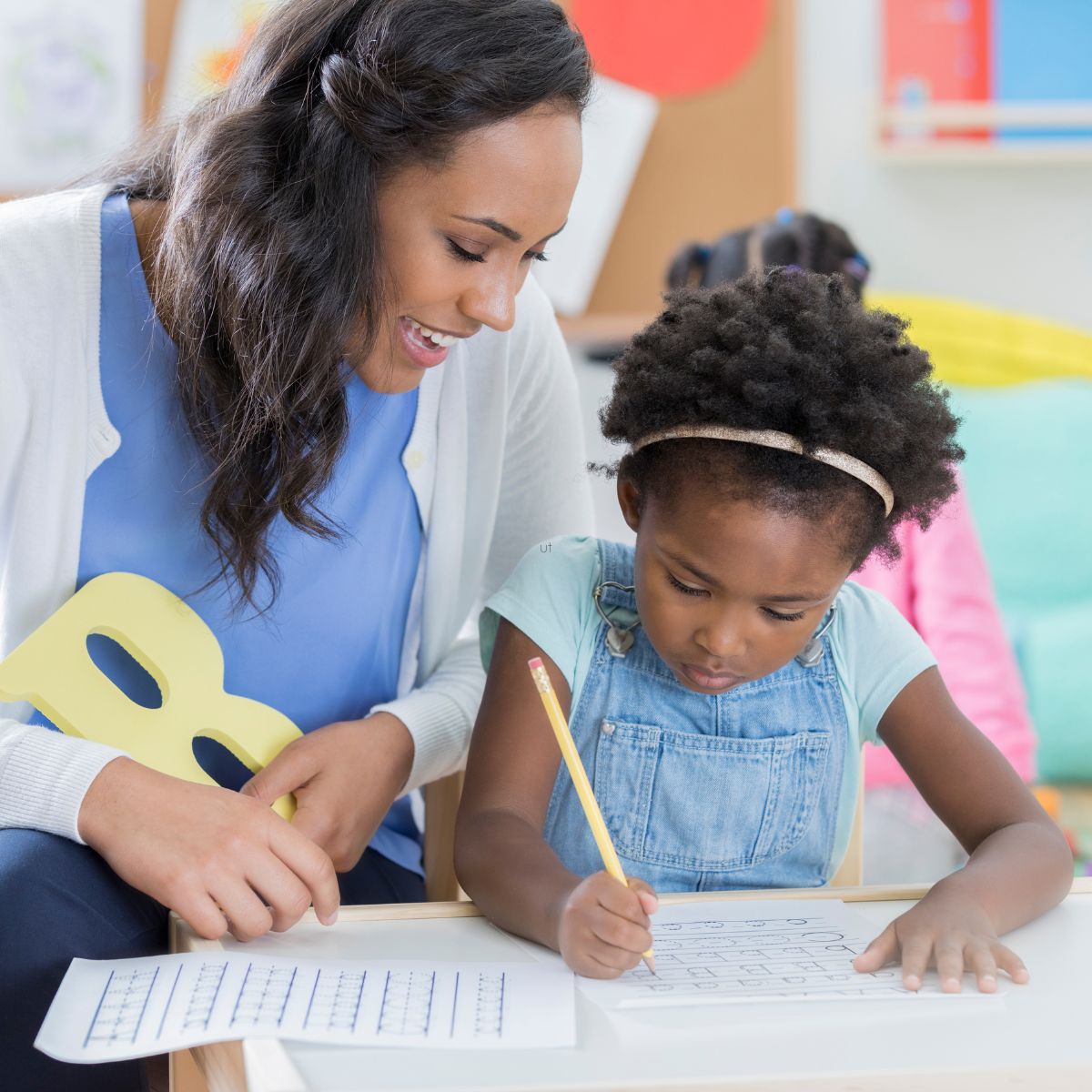 A tutor teaching handwriting to a student.